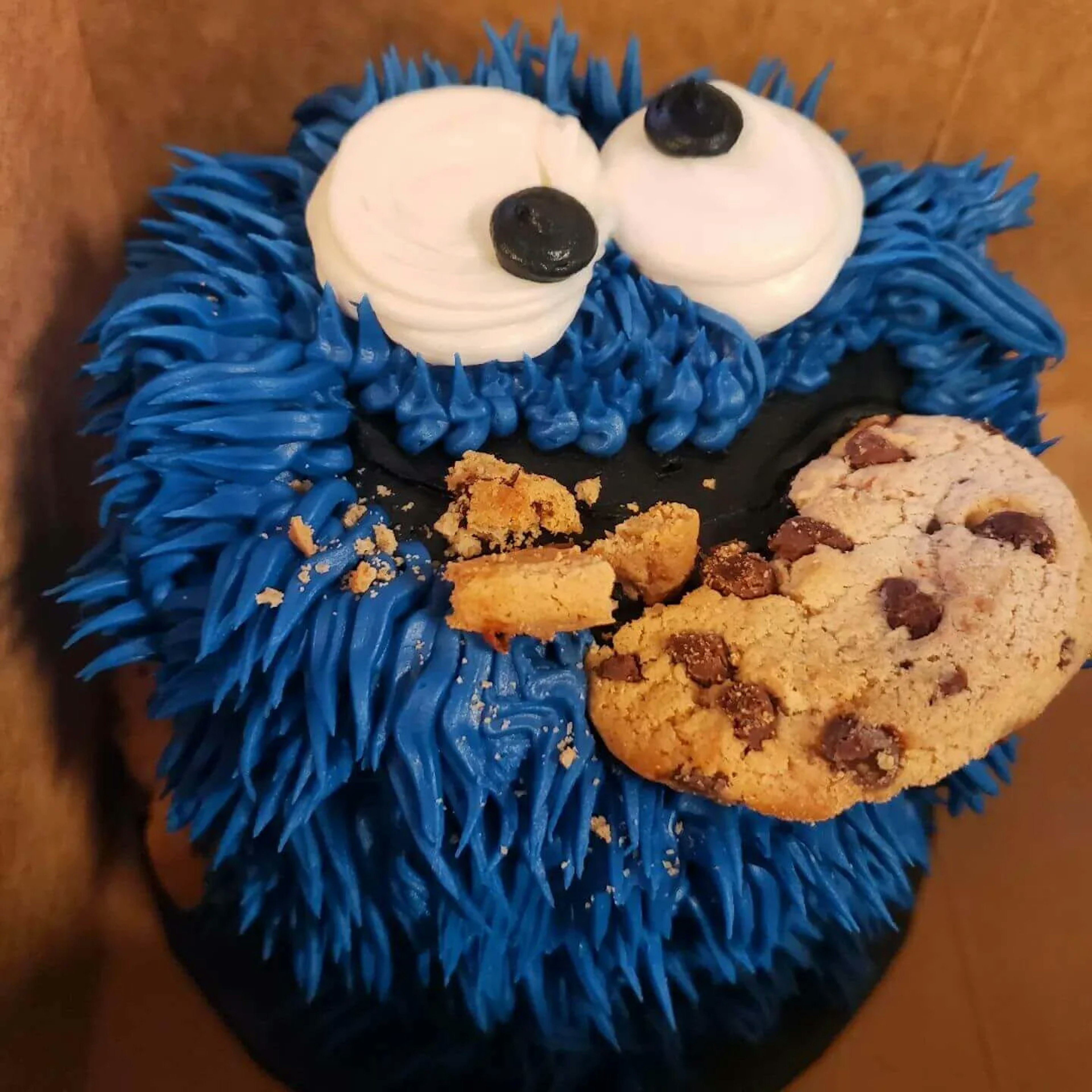 A blue cake in the shape of cookie monster