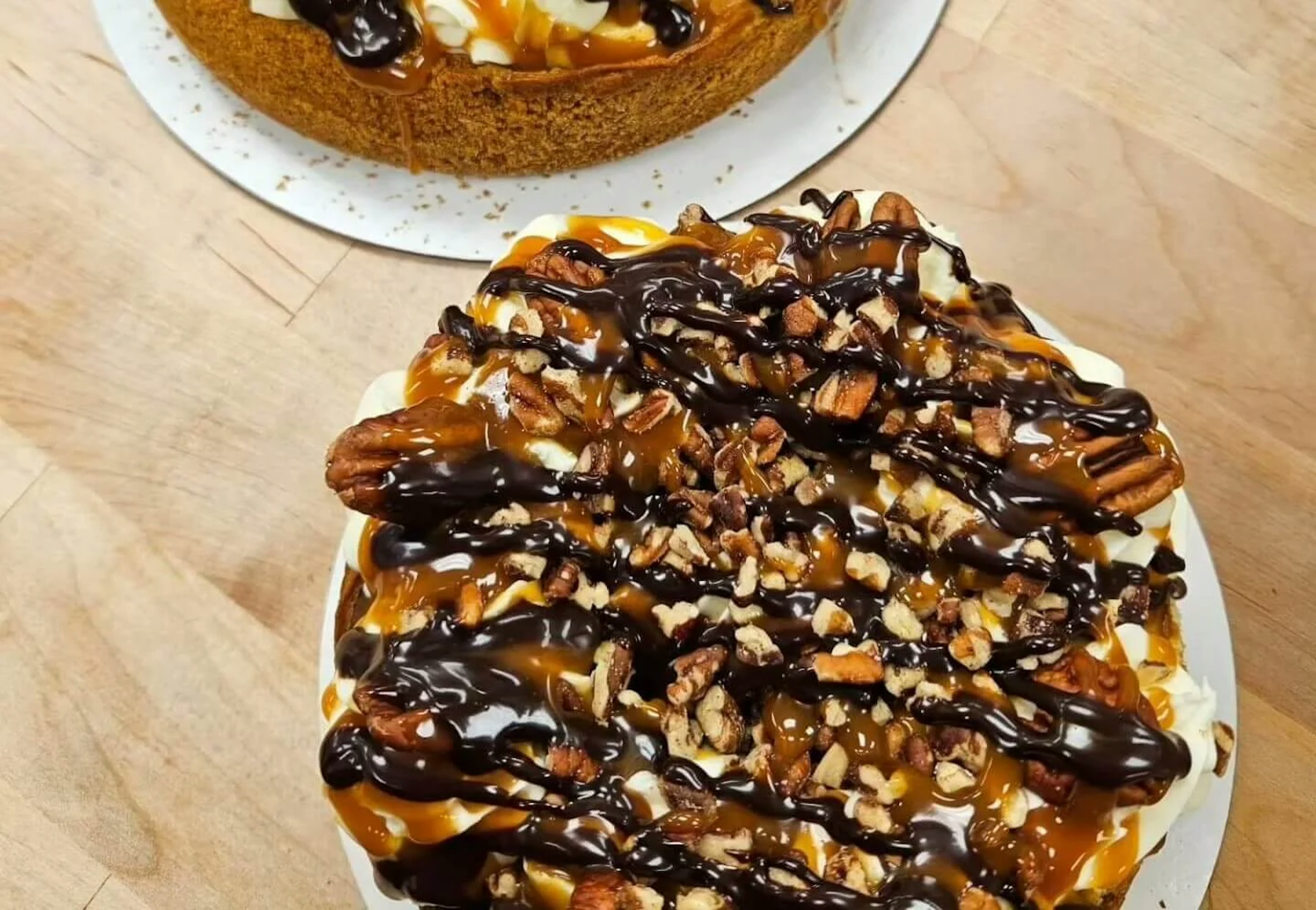 A cake covered in caramel, fudge and pecans.
