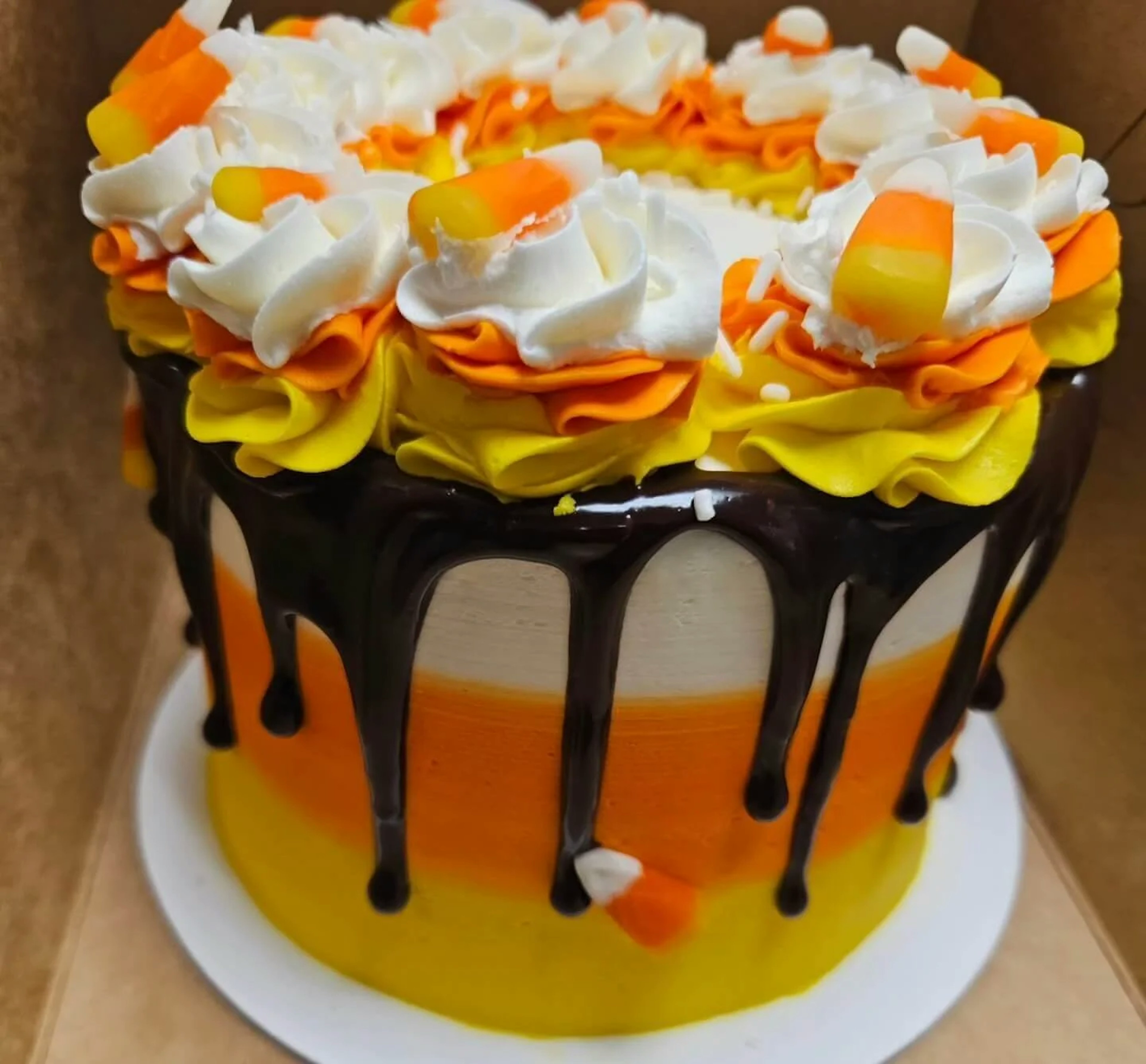 Orange and white cake a chocolate drizzle. Topped with candy corn.